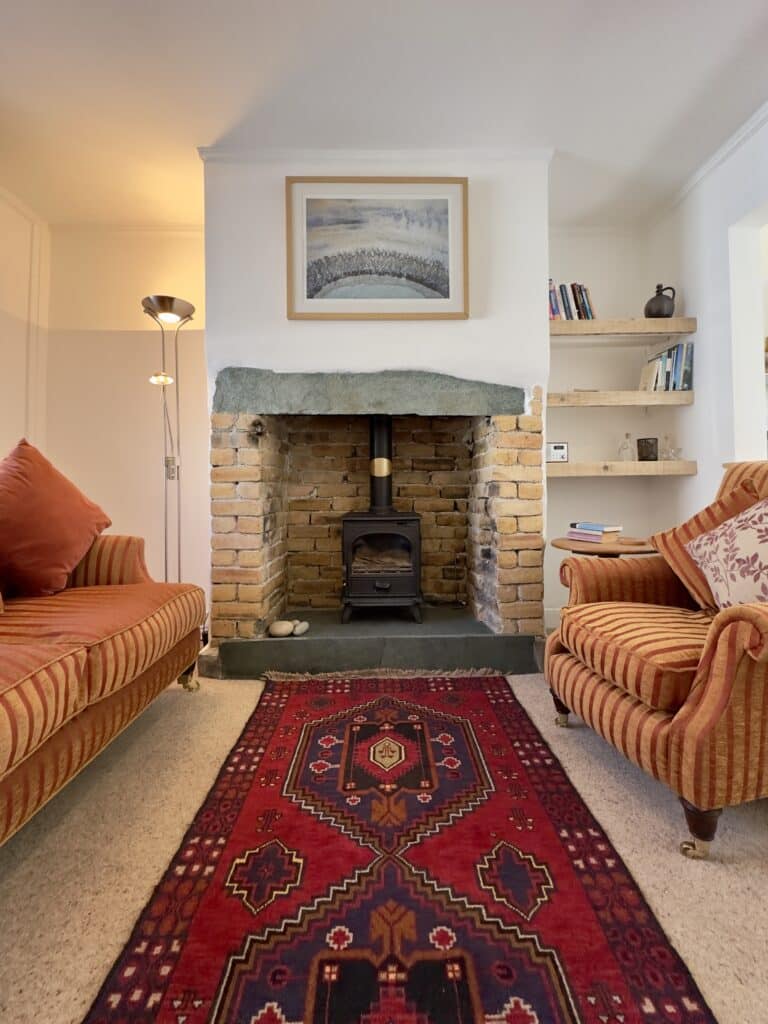 Cosy living room at Crofts Cottage in Keswick with feature fireplace and comfortable seating