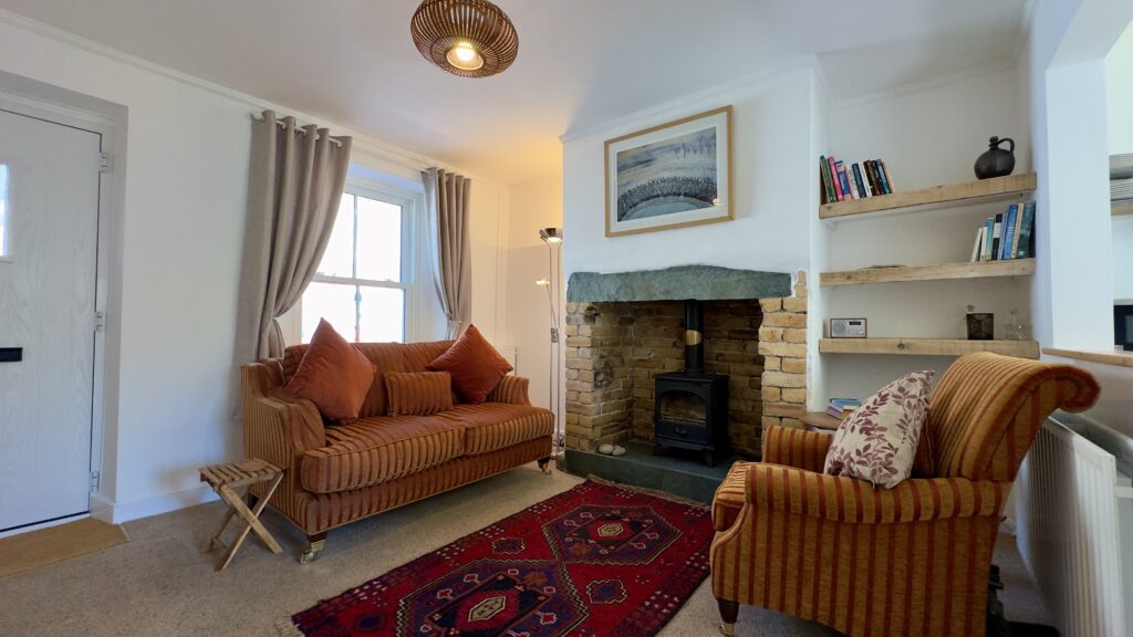 Comfortable living room at Crofts Cottage with sofa, armchairs and traditional fireplace