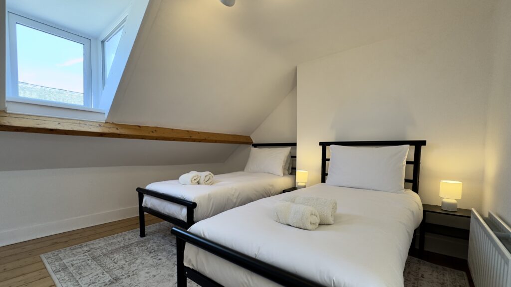 Twin bedroom beneath the sloping roof at Crofts Cottage in Keswick